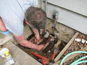 an Allen sprinkler repair Tech checks sprinkler connections